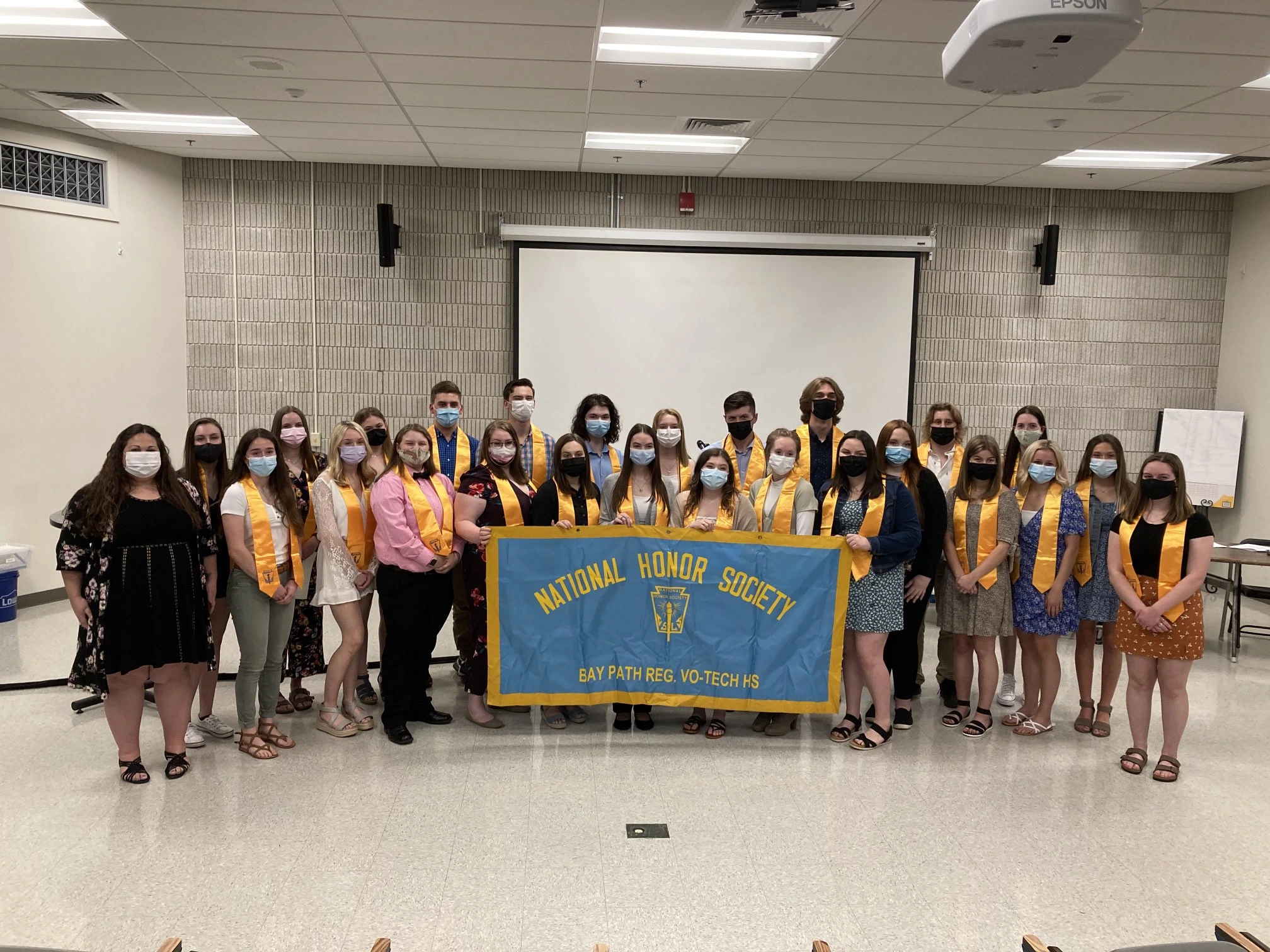 Clubs banner image showing the Bay Path National Honors Society Holding a Banner